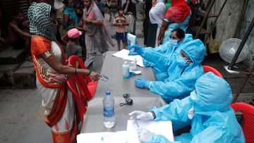 A healthcare worker checks the temperature of a resident during a medical campaign for the coronavirus disease at a slum area in Mumbai.
