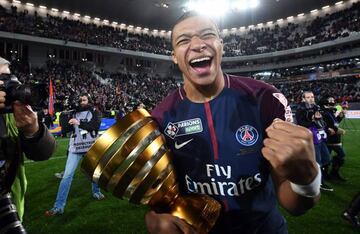 TOPSHOT - Paris Saint-Germain's French forward Kylian Mbappé holds the trophy as he celebrates after victory in the French League Cup final football match between Monaco (ASM) and Paris Saint-Germain (PSG) at The Matmut Atlantique Stadium in Bordeaux, sou