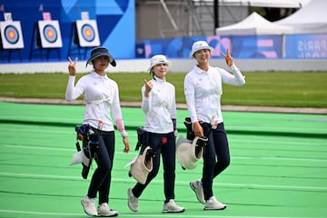 (FromR) South Korea's Lim Si-hyeon, South Korea's Jeon Hun-young and South Korea's Nam Su-hyeon return after collecting their arrows during the Women's Individual Preliminary Round during the Paris 2024 Olympic Games at the Esplanade des Invalides in Paris on July 25, 2024. (Photo by Punit PARANJPE / AFP)