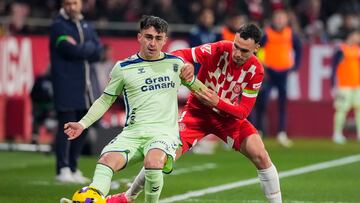 GIRONA, 03/02/2025.- El centrocampista de la UD Las Palmas Alberto Moleiro (i) pelea un balón con el defensa del Girona Arnau Martínez durante el encuentro correspondiente a la jornada 22 de Laliga EA Sports que disputan hoy lunes Girona y Las Palmas en el estadio de Montilivi, en Girona. EFE /David Borrat
