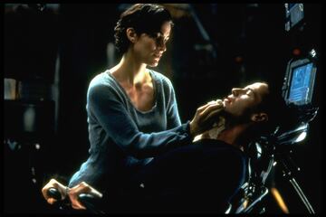 No hay Neo sin Trinity, eso seguro. En la primera película de la saga, Trinity (Carrie-Anne Moss) es una poderosa hacker que participa en la misión para despertar a Neo de la realidad simulada que es Matrix. Es su compañera y en parte maestra en la rebelión de los humanos contra las máquinas, y en las cintas posteriores iniciará una relación con Neo. Dónde ver: Primer Video, Max y Movistar+