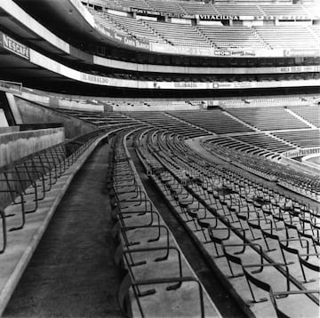 Gradería baja terminada, seguida de plateas bajas y palcos protegidos por la tribuna superior.