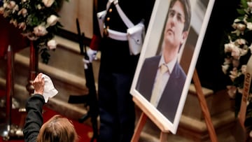 An attendee holds up a napkin in front of a displayed portrait of Colombian Senator Miguel Uribe Turbay, who died two months after he was shot in the head at a campaign event, during a tribute at the Colombian congress, in Bogota, Colombia August 12, 2025. REUTERS/Luisa Gonzalez