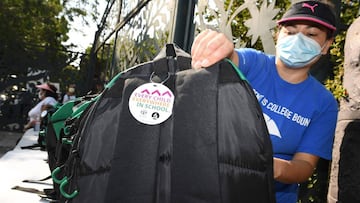 A volunteer organizes backpacks filled with school supplies for distribution to neighborhood families in need, August 14, 2020 in Los Angeles, California. - The back-to-school giveaway is being held as part of Adventist Health White Memorial hospital&#039