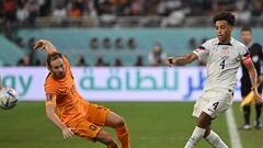 Netherlands' defender #17 Daley Blind (L) and USA's midfielder #04 Tyler Adams fight for the ball during the Qatar 2022 World Cup round of 16 football match between the Netherlands and USA at Khalifa International Stadium in Doha on December 3, 2022. (Photo by Alberto PIZZOLI / AFP)