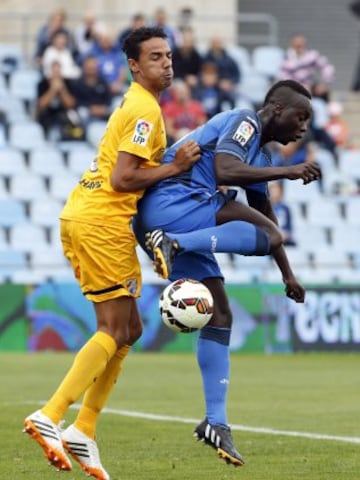 El delantero senegalés del Getafe, Babá Diawara, intenta controlar el balón ante el defensa brasileño del Málaga, Weligton Robson de Oliveira, durante el partido de Liga de Primera División que los dos equipos disputan en el Coliseum Alfonso Pérez, en Getafe.