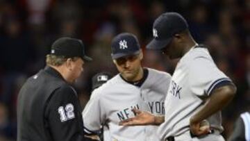 El lanzador de los Yanquis de Nueva York Michael Pineda (derecha) muestra su mano al juez Gerry Davis (izquierda). Fue expulsado por utilizar resina. 