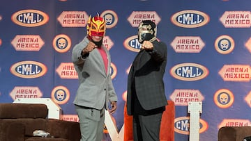 Dragón Rojo Jr., (izq) y Templario (der) posan para foto después de firmar el contrato de lucha de máscara vs máscara.