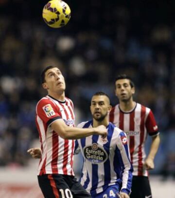 El defensa del Athletic Club Óscar de Marcos lucha el balón con el argentino Luis Carlos Fariña, del Deportivo de La Coruña, durante el partido de la decimoséptima jornada de la Liga de Primera División que se disputa esta noche en el estadio de Riazor