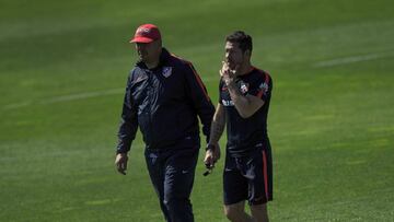 Simeone conversa con el Mono Burgos durante un entrenamiento.
