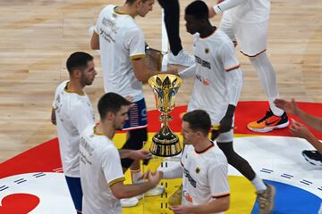 Jugadores de ambas selecciones se saludan junto al trofeo del Mundial antes del inicio del partido.