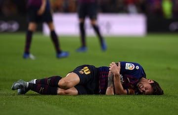 Messi lies on the Camp Nou pitch awaiting attention.