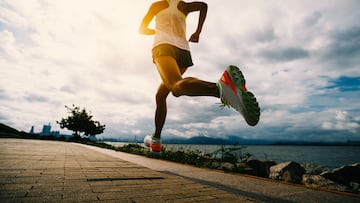 Fitness woman running training for marathon on sunny coast trail