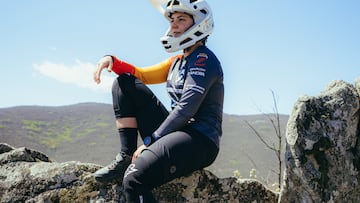 Sara Yusto, sentada, con su casco y su equipación MTB en la montaña.
