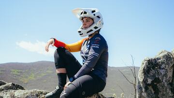 Sara Yusto, sentada, con su casco y su equipación MTB en la montaña.