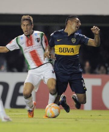Andrés Chávez(d) de Boca Juniors disputa la pelota con Agustin Farias(i).
