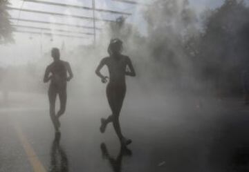 Kumi Otoshi and Lorena Luaces pasan por una zona de refresco durante la prueba de los 20 km marcha femenino en el Campeonato Mundial de Atletismo de la IAAF en el estadio Luzhniki de Moscú