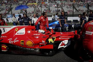 Sebastian Vettel, dentro del coche, es ayudado por sus mecánicos.