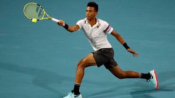 El canadiense Felix Auger-Aliassime devuelve una bola a Borna Coric en el Abierto de Tenis de Miami, Florida (EE.UU.).