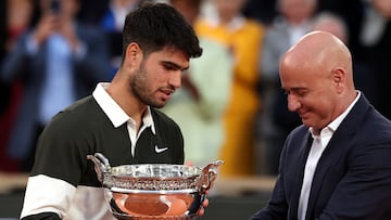 Carlos Alcaraz recibe el trofeo de campeón de Roland Garros de manos de Andre Agassi.
