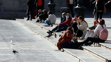 GRAFCVA1878. VALENCIA, 16/02/2021.--Un grupo de jóvenes almuerzan al sol en la Plaza de la Virgen de Valencia cuando todavía siguen en vigor el cierre de la hostelería para bajar la alta incidencia de contagios por Covid-19 en la Comunitat Valenciana.".EFE/ Kai Försterling