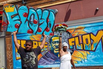 People brandish signs and flowers by a makeshift memorial for George Floyd who died while in custody of the Minneapolis police, on May 30, 2020 in Minneapolis, Minnesota. - Demonstrations are being held across the US after George Floyd died in police custody on May 25. (Photo by Kerem Yucel / AFP)