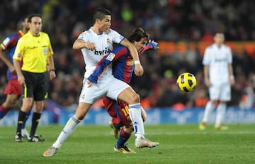 Cristiano Ronaldo battles with Lionel Messi for the ball in El Clásico