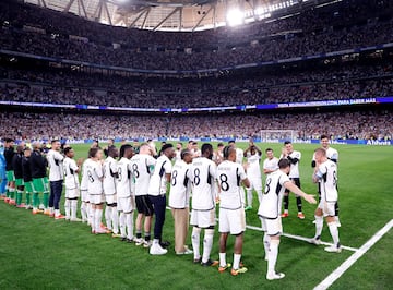 Toni Kroos, recibe el reconocimiento de los jugadores de ambos equipos y aficionados en el estadio Santiago Bernabéu. En la imagen, el futbolista alemán atraviesa con honores el pasillo formado por los conjuntos del Real Madrid y Betis.