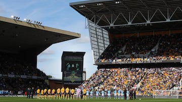 Players and officials stand in silence for Queen Elizabeth II ahead of the English Premier League football match between Wolverhampton Wanderers and Manchester City at the Molineux stadium in Wolverhampton, central England on September 17, 2022. (Photo by Geoff Caddick / AFP) / RESTRICTED TO EDITORIAL USE. No use with unauthorized audio, video, data, fixture lists, club/league logos or 'live' services. Online in-match use limited to 120 images. An additional 40 images may be used in extra time. No video emulation. Social media in-match use limited to 120 images. An additional 40 images may be used in extra time. No use in betting publications, games or single club/league/player publications. / 