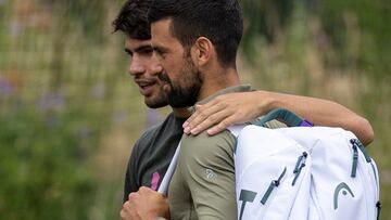 Alcaraz y Djokovic se saludan antes de empezar su entrenamiento en Wimbledon.