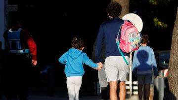 A man holds hands with a girl, as they arrive at a school, amid a rise in coronavirus disease (COVID-19) cases , in Buenos Aires, Argentina April 19, 2021. REUTERS/Agustin Marcarian