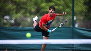 Spain's Carlos Alcaraz serves as he warms up during the 2025 Wimbledon Championships at The All England Lawn Tennis and Croquet Club in Wimbledon, southwest London, on June 29, 2025. (Photo by HENRY NICHOLLS / AFP) / RESTRICTED TO EDITORIAL USE