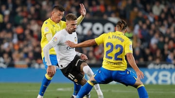 VALENCIA, 06/01/2023.- El centrocampista del Valencia, Samu Castillejo (c), intenta llevarse el balón ante los defensores del Cádiz, el uruguayo Luis Alfonso "Pacha" Espino (d) y Rubén Alcaraz, durante el encuentro correspondiente a la jornada 16 que disputan hoy viernes en el estadio valencianista de Mestalla. EFE / Juan Carlos Cárdenas.
