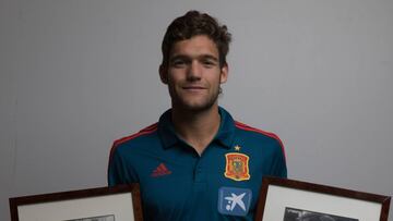 El futbolista Marcos Alonso posa con los retratos de su abuelo " Marquitos" y su padre Marcos Alonso.