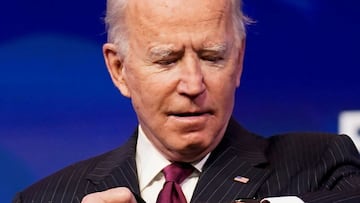 FILE PHOTO: U.S. President-elect Joe Biden looks at his watch as he arrives to announce former South Bend, Indiana Mayor Pete Buttigieg as his nominee for secretary of transportation during a news conference at Biden's transition headquarters in Wilm