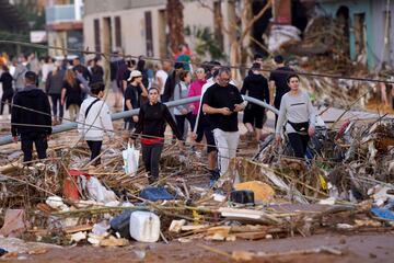 Los residentes caminan por una calle después de las inundaciones en Paiporta, cerca de Valencia, España.