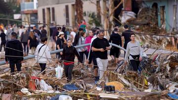 Los residentes caminan por una calle después de las inundaciones en Paiporta, cerca de Valencia, España.