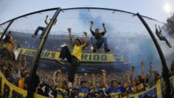 Hinchas del Boca Juniors suben a las mallas de protección en el juego de su equipo ante River Plate, durante su partido del torneo argentino en el estadio Alberto J. Armando (Bombonera) en Buenos Aires (Argentina).