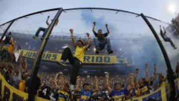 Hinchas del Boca Juniors suben a las mallas de protecci&oacute;n en el juego de su equipo ante River Plate, durante su partido del torneo argentino en el estadio Alberto J. Armando (Bombonera) en Buenos Aires (Argentina).