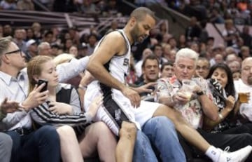 El francés Tony Parker (c) de San Antonio Spurs cae sobre la primera fila de espectadores.