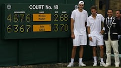 John Isner, Nicolas Mahut y el juez de silla Mohamed Lahyani posan con el hist&oacute;rico marcador del encuentro entre ambos tenistas, que termin&oacute; con un marcador de 70-68 en el quinto set.