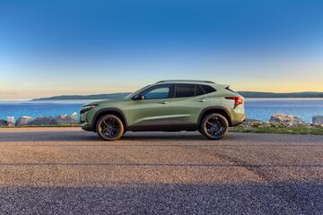 Driver’s side view of Chevrolet Trax ACTIV in Cacti Green parked on a road in front of a lake. Pre-production model shown. Actual production model may vary. Available in spring 2023. Cacti Green exterior color late availability.