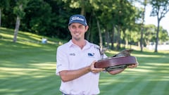 El golfista estadounidense J.T. Poston posa con el título de campeón del John Deere Classic.