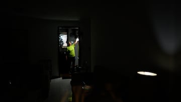 Carolina González prende bombillo recargable en la cocina de su casa durante una falla de servicio eléctrico que dejó un sector sin luz por varios días en la urbanización el Cafetal, Caracas, Venezuela, el 7 de Septiembre de 2023