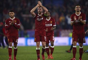 Alex Oxlade-Chamberlain of Liverpool CF (L), Jordan Henderson of Liverpool FC and Dejan Lovren of Liverpool FC (R) waves to the fans after the end of the UEFA Champions League group E match between Sevilla FC and Liverpool FC at Estadio Ramon Sanchez Pizj