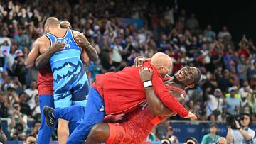 Cuba's Mijain Lopez Nunez celebrates with his coach after beating Chile's Yasmani Acosta Fernandez in their men's greco-roman 130kg wrestling final match at the Champ-de-Mars Arena during the Paris 2024 Olympic Games, in Paris on August 6, 2024. (Photo by Punit PARANJPE / AFP)