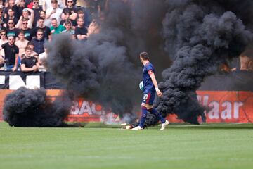 El partido llevaba seis minutos de juego cuando varios hinchas locales saltaron al campo con begalas y botes de humo. Su intención era reventar el partido. Y lo consiguieron.