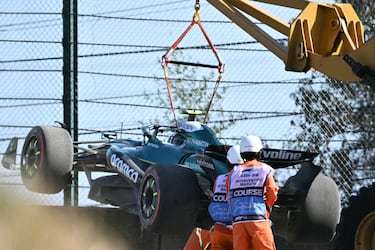 Los comisarios retiran el coche del piloto español Fernando Alonso después de quedarse atrapado en la grava en la segunda sesión de prácticas del Gran Premio de Japón de Fórmula Uno en el circuito de Suzuka en Suzuka.