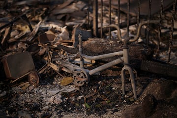 Los restos de un vehculo de pedales quemado se encuentran entre los escombros, mientras los fuertes vientos que alimentan los devastadores incendios forestales en el rea de Los ?ngeles.