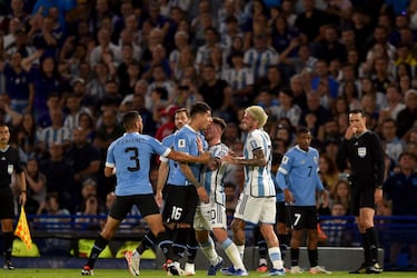 El argentino Lionel Messi detiene al uruguayo Mathias Olivera, mientras discute con el argentino Rodrigo De Paul.